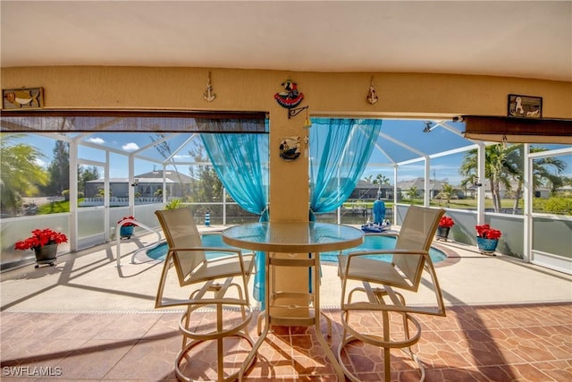 view of patio featuring outdoor dining area and a lanai