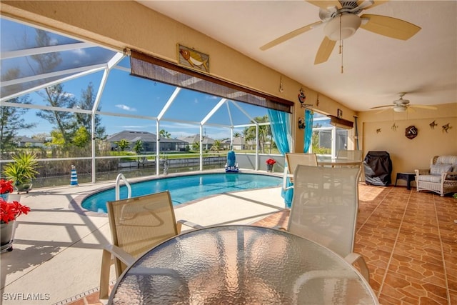 pool featuring a ceiling fan, outdoor dining space, glass enclosure, and a patio area