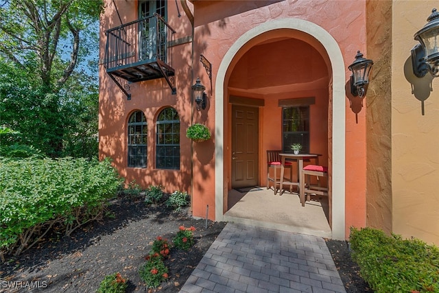 view of exterior entry with a balcony