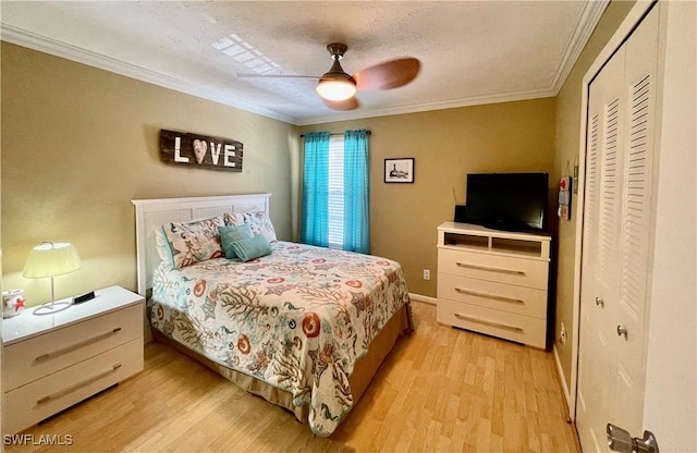 bedroom with a closet, a textured ceiling, ceiling fan, light hardwood / wood-style floors, and ornamental molding