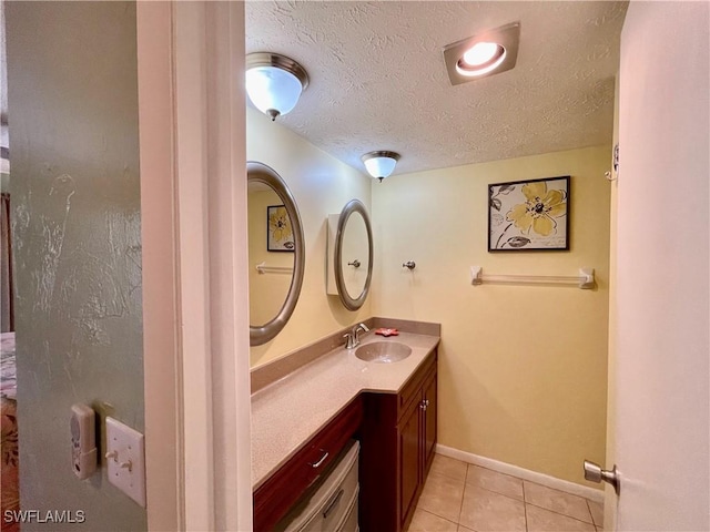 bathroom with tile patterned floors, vanity, and a textured ceiling