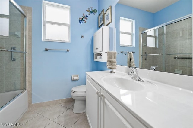 full bathroom featuring tile patterned flooring, bath / shower combo with glass door, vanity, and toilet