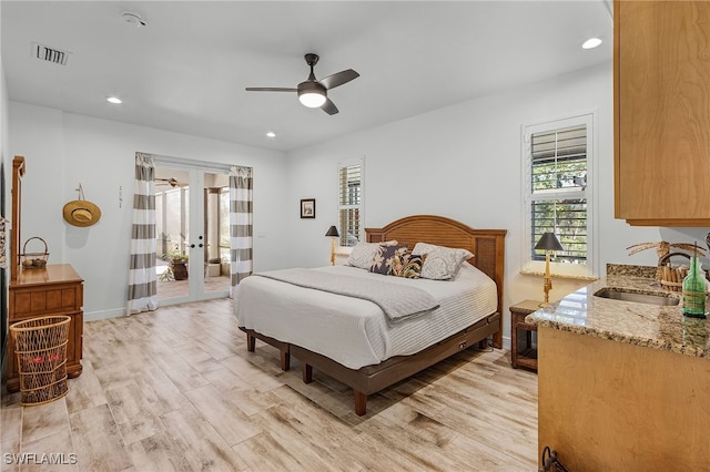 15791 Quail Trl, Bokeelia, FL 33922 - bedroom with french doors, light wood finished floors, a sink, and visible vents