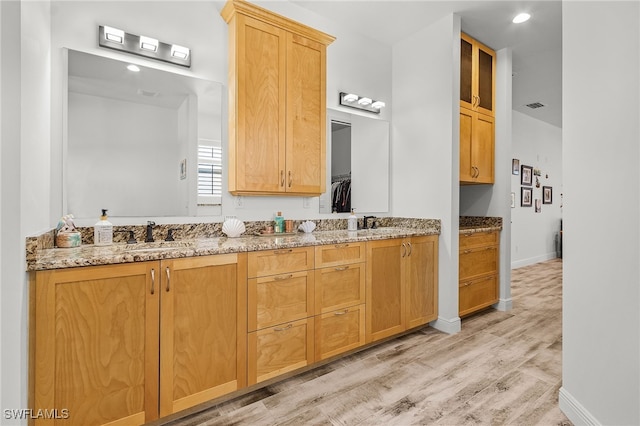 15791 Quail Trl, Bokeelia, FL 33922 - bathroom with visible vents, baseboards, a sink, double vanity, and wood finished floors