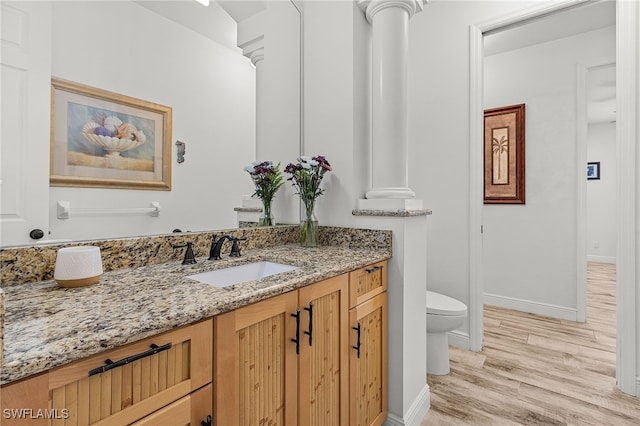 15791 Quail Trl, Bokeelia, FL 33922 - bathroom featuring baseboards, toilet, decorative columns, vanity, and wood finished floors
