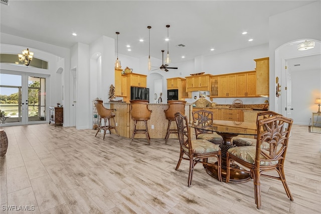 15791 Quail Trl, Bokeelia, FL 33922 - dining area with recessed lighting, arched walkways, light wood-style floors, and ceiling fan with notable chandelier