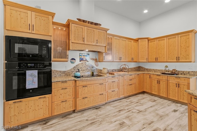 15791 Quail Trl, Bokeelia, FL 33922 - kitchen featuring light wood-type flooring, black appliances, light stone counters, and light brown cabinets