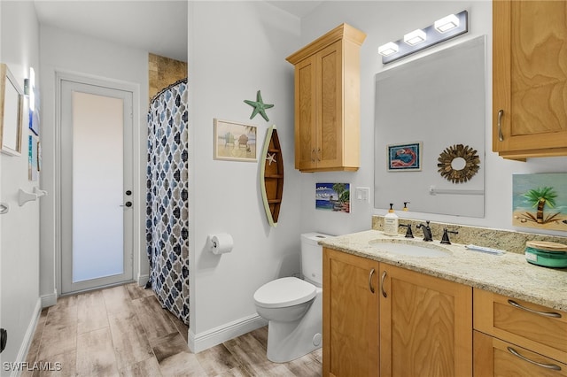 15791 Quail Trl, Bokeelia, FL 33922 - bathroom featuring baseboards, curtained shower, toilet, vanity, and wood finished floors