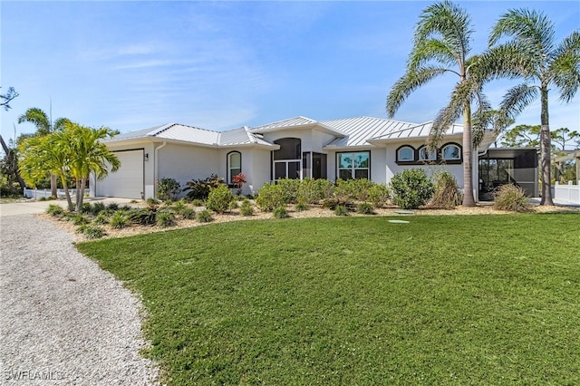 15791 Quail Trl, Bokeelia, FL 33922 - view of front of house with stucco siding, driveway, an attached garage, a standing seam roof, and metal roof