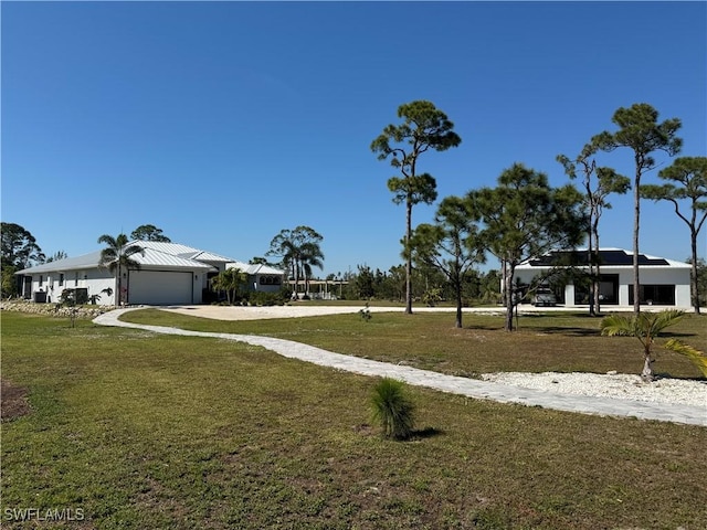 view of yard featuring a garage and driveway