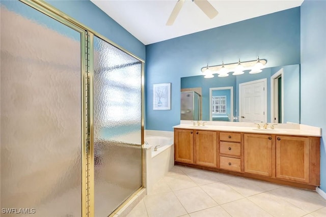 bathroom featuring a stall shower, tile patterned flooring, a garden tub, and a sink