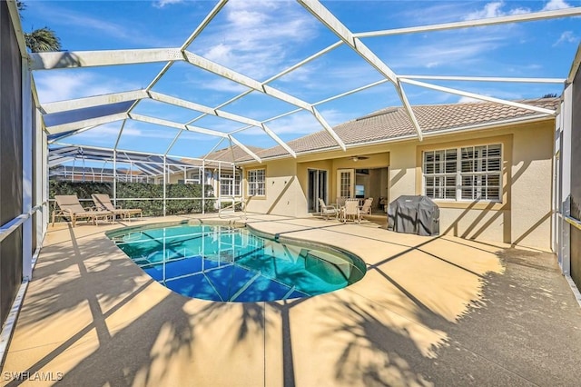 outdoor pool featuring a ceiling fan, a lanai, a patio area, and a grill