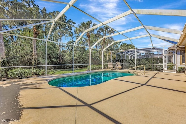 pool with glass enclosure and a patio