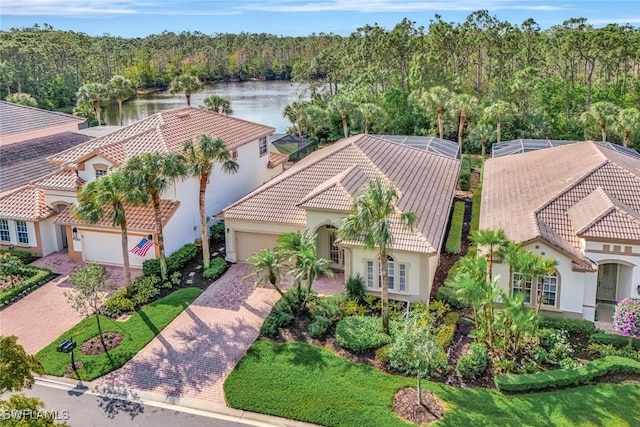 drone / aerial view with a water view and a forest view