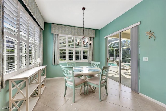 dining space featuring an inviting chandelier, light tile patterned floors, and baseboards