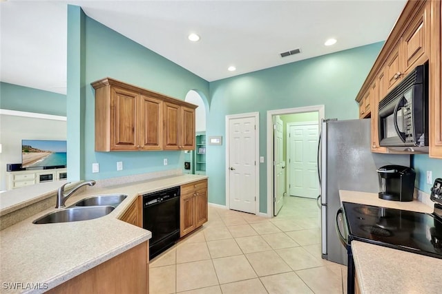 kitchen featuring light tile patterned floors, visible vents, light countertops, black appliances, and a sink