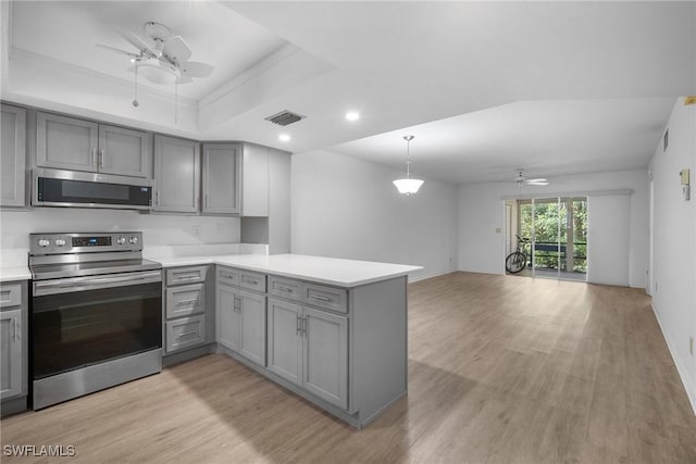 kitchen featuring pendant lighting, stainless steel appliances, kitchen peninsula, gray cabinets, and a raised ceiling