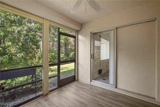 unfurnished sunroom featuring ceiling fan