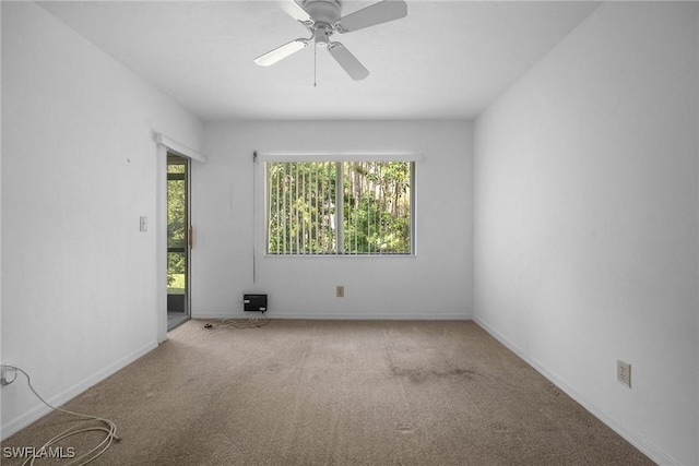 carpeted spare room with ceiling fan