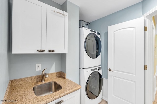 clothes washing area featuring sink and stacked washer / drying machine