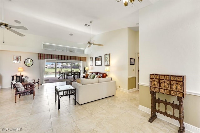 living room with light tile patterned flooring, visible vents, baseboards, and ceiling fan with notable chandelier