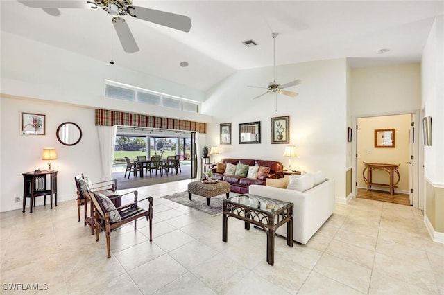 living area with light tile patterned floors, visible vents, a ceiling fan, high vaulted ceiling, and baseboards