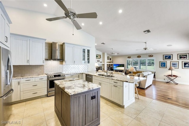 kitchen with a peninsula, visible vents, open floor plan, appliances with stainless steel finishes, and wall chimney exhaust hood