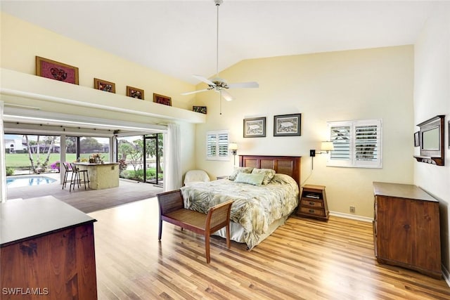 bedroom with access to outside, light wood finished floors, high vaulted ceiling, and baseboards