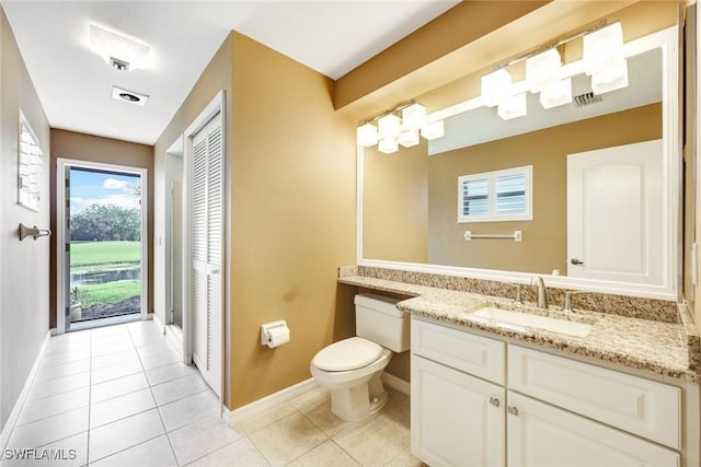 bathroom featuring vanity, tile patterned flooring, toilet, and baseboards