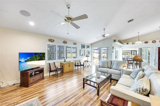 living area featuring lofted ceiling, light wood-type flooring, visible vents, and a ceiling fan