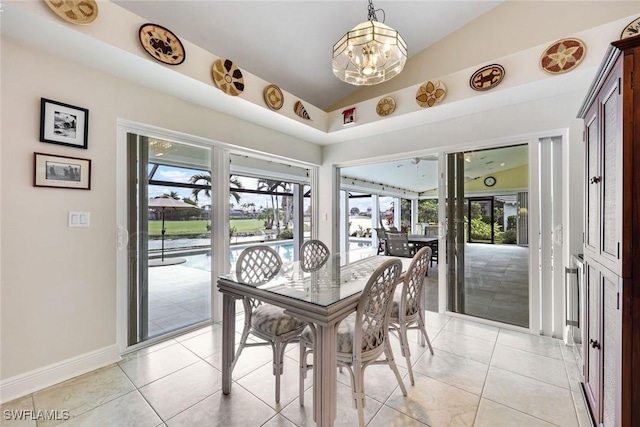 dining space featuring a chandelier, light tile patterned flooring, a sunroom, baseboards, and vaulted ceiling