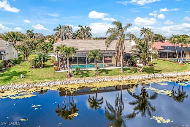 back of property featuring a lanai, a water view, an outdoor pool, and a yard