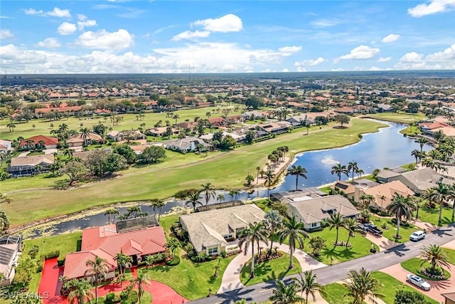 drone / aerial view with a residential view, view of golf course, and a water view