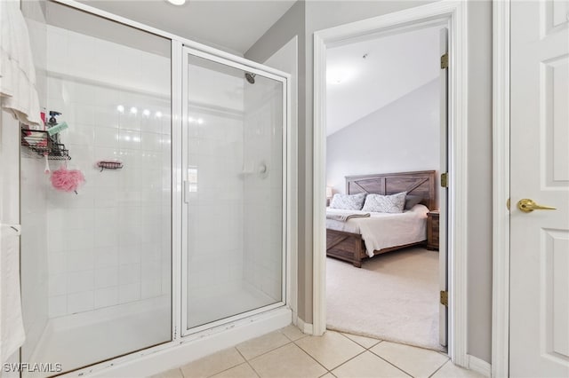 bathroom featuring lofted ceiling, tile patterned flooring, and a shower with shower door