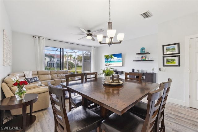 dining area featuring ceiling fan with notable chandelier and light hardwood / wood-style floors