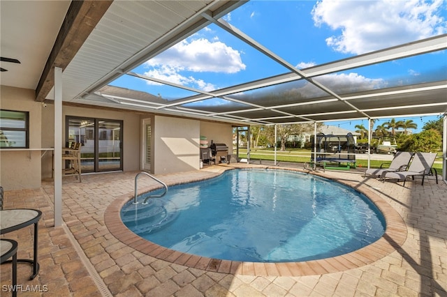 pool with glass enclosure, a patio, and area for grilling