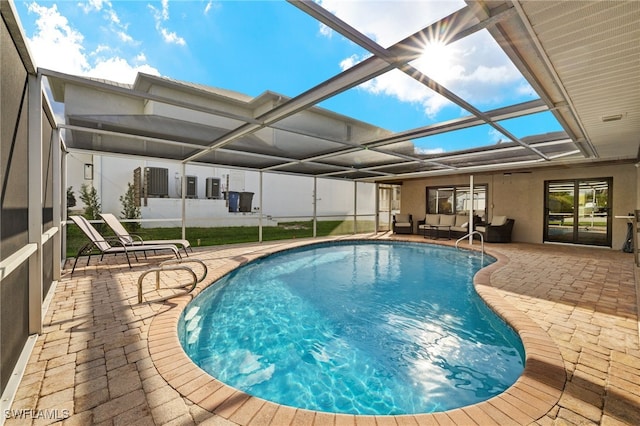 pool featuring glass enclosure, a patio area, and outdoor lounge area