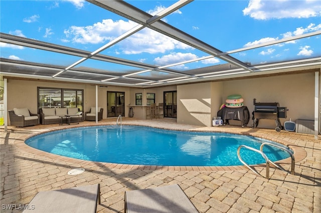 outdoor pool featuring glass enclosure, a patio area, and outdoor lounge area