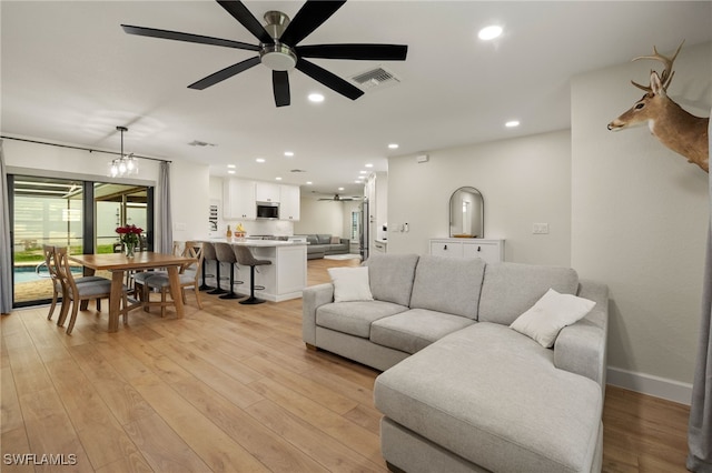 living room featuring light wood-style floors, recessed lighting, visible vents, and a ceiling fan