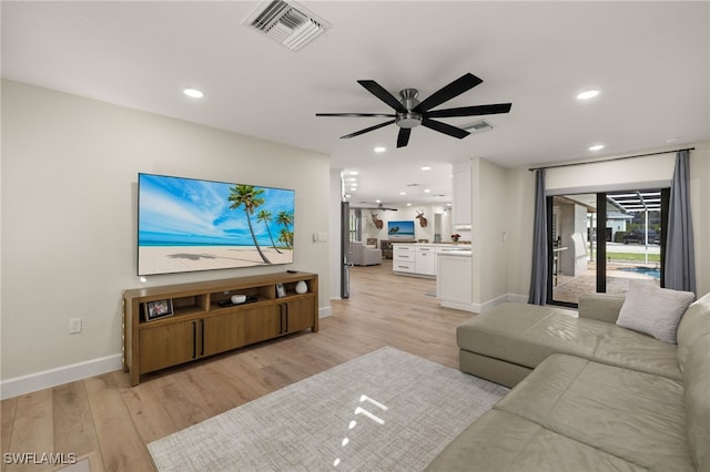 living area featuring a ceiling fan, visible vents, and light wood finished floors