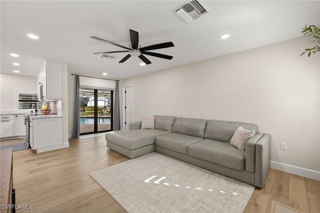 living room featuring light wood finished floors, visible vents, and recessed lighting