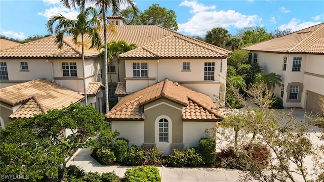 mediterranean / spanish house with a tile roof and stucco siding