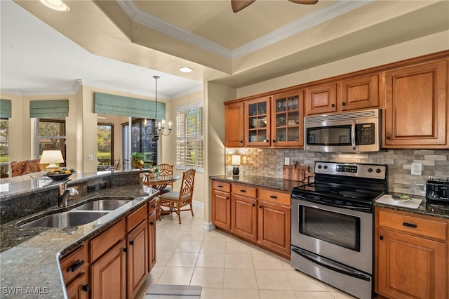 kitchen with glass insert cabinets, dark stone counters, stainless steel appliances, and crown molding