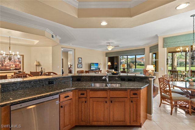 kitchen with dark stone counters, dishwasher, open floor plan, decorative light fixtures, and a sink