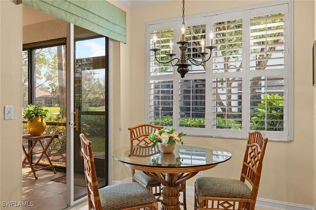 dining room with a chandelier, baseboards, and tile patterned floors