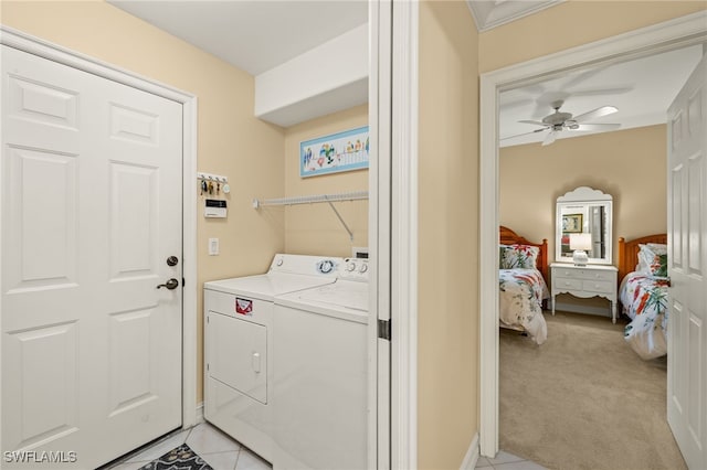 clothes washing area featuring laundry area, light tile patterned floors, a ceiling fan, light colored carpet, and independent washer and dryer