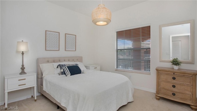 bedroom with light carpet and baseboards