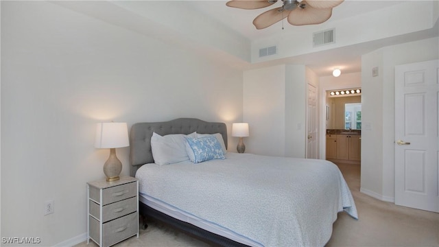 bedroom featuring baseboards, visible vents, connected bathroom, and light colored carpet