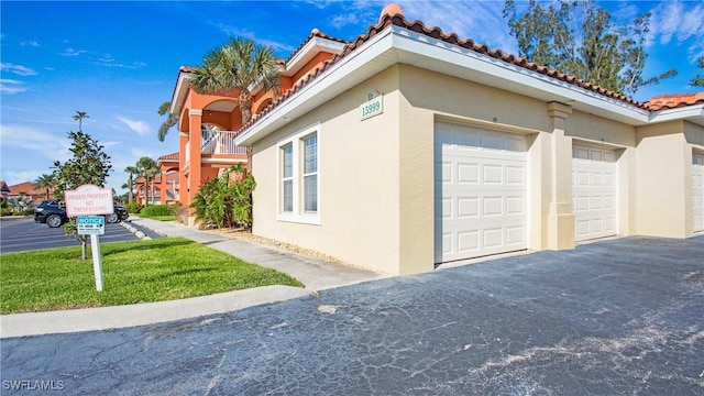 view of home's exterior with a tiled roof and stucco siding