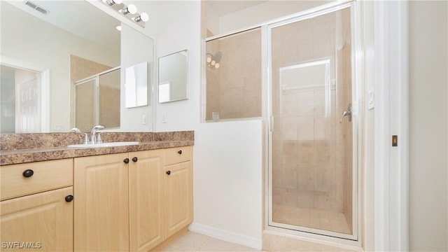 full bath featuring tile patterned flooring, visible vents, a shower stall, and vanity